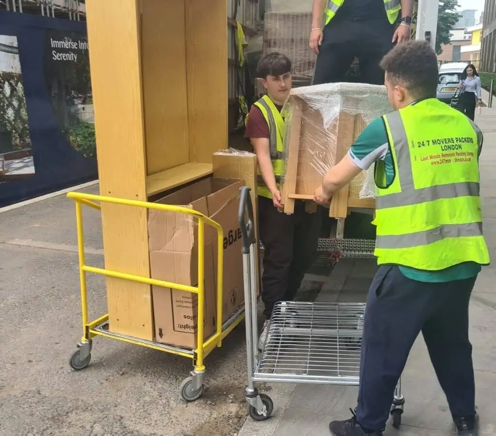 two man are loading packed items into the truck\van