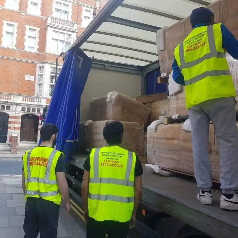 Two man are standing near the truck and other is on the truck