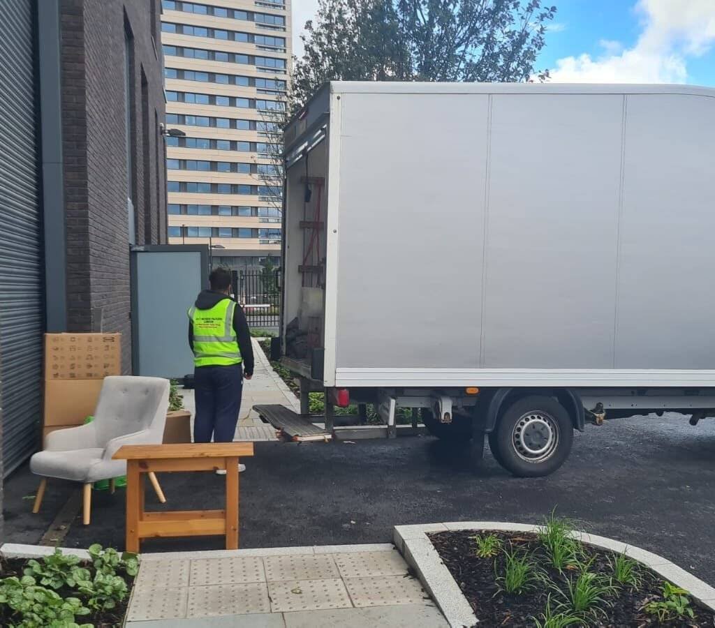 A worker of 24/7 Movers Packers London is standing with the moving van.
