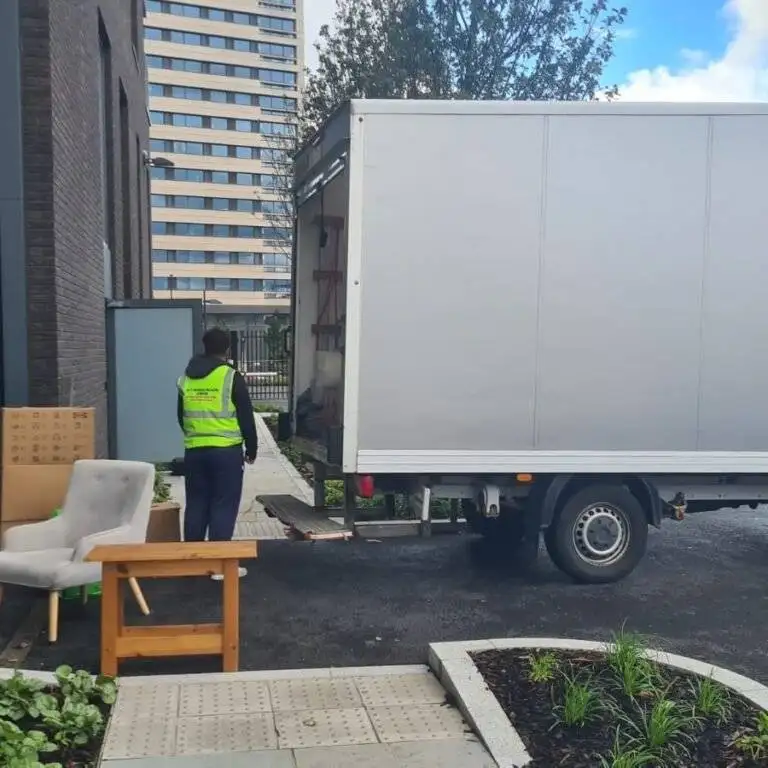 A worker of 24/7 Movers Packers London is standing with the moving van.