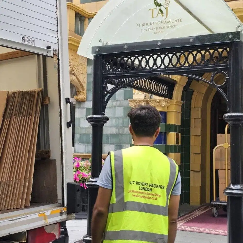 24/7 Movers Packers London staff member standing near moving truck outside Taj 51 Buckingham Gate Suites and Residences, preparing for luxury removals service in Central London.