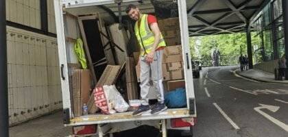 A worker of 24/7 Movers Packers London is loading packed stuff in the moving van